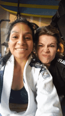 two women are posing for a picture and one is wearing a jacket that says ufc on it