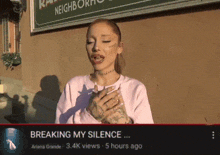 ariana grande is singing breaking my silence in front of a sign that says neighborhood