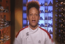 a chef wearing a white jacket with hk on the front