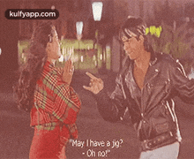a man and a woman are standing next to each other talking .