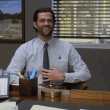 a man in a striped shirt and tie is smiling