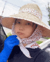 a woman wearing a straw hat and blue gloves with pixverse written on the bottom right