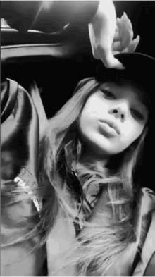a black and white photo of a woman wearing a baseball cap