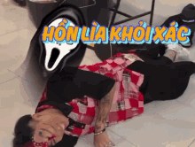 a person is laying on the floor with a scream face behind them that says honlia khoixact