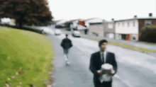 a blurry picture of a man in a suit holding a dog