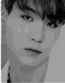 a black and white photo of a young man 's face with a serious look on his face .