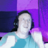 a man wearing headphones and a blue shirt is making a funny face