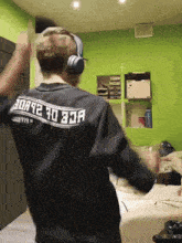 a man wearing headphones and a shirt that says ace de jada