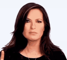 a woman with long dark hair is giving a thumbs down sign