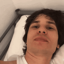a man laying on a bed with a white pillow