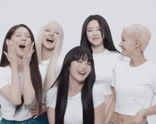 a group of young women are posing for a picture and one of them is wearing a white shirt