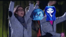 a woman with glasses holds her arms up in the air with a picture of a girl with blue hair behind her