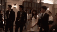 a group of people standing in a room with blink group jessica written on the bottom