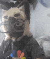 a stuffed animal wearing glasses and a t-shirt with a sunflower on it