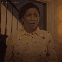 a woman with a surprised look on her face is wearing a yellow shirt