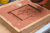 a piece of clay in a wooden box that says makar on it