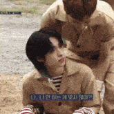 a man sitting on another man 's lap with korean writing on the bottom