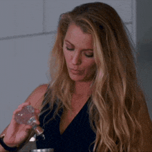 a woman with long blonde hair is holding a clear object