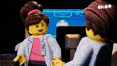 a man and a woman are talking to each other in front of a computer screen that says okco