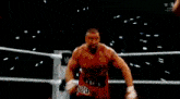 two men are fighting in a wrestling ring without shirts .