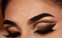 a close up of a woman 's eye with smokey eye makeup and long eyelashes .