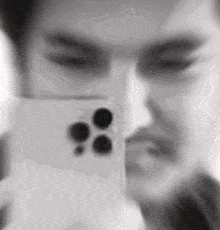 a blurred image of a man holding a cell phone in front of his face