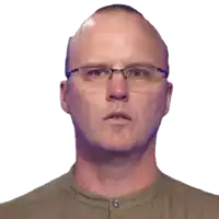 a bald man wearing glasses looks at the camera with a surprised look on his face