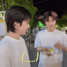 a man holding a plate of food next to another man with a sign that says ' sua ' on it