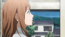 a girl with long brown hair looks out a window at a house