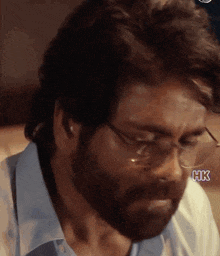 a man with glasses and a beard has the letters hk on his forehead