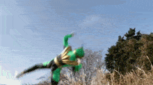 a person in a green costume is jumping in the air .