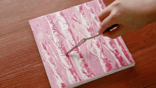 a painting of pink and white stripes is being created