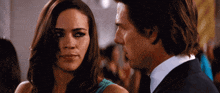 a man and a woman are looking at each other in a crowd