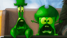two green cartoon characters sitting on a couch