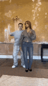 a man and a woman are dancing in front of a wall