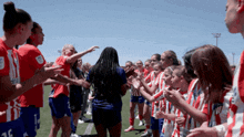a group of female soccer players wearing red and white striped uniforms with the number 16 on the back