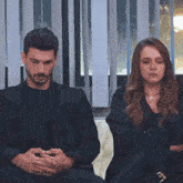 a man and a woman are sitting next to each other with their arms crossed