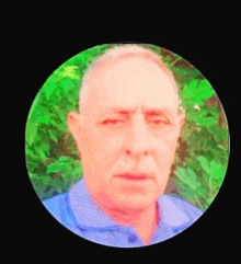 a man in a blue shirt is taking a selfie in a circle .