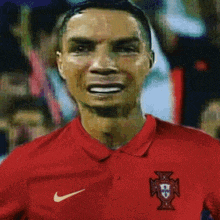 a man wearing a red nike polo shirt is smiling .