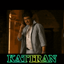 a man giving a thumbs up in front of a poster that says kattran