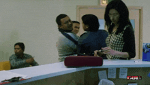 a woman standing at a counter with the word full on the bottom