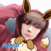 a boy wearing a red hoodie with eevee ears