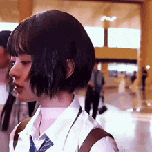 a girl with short hair is wearing a white shirt and a tie