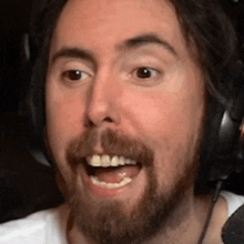 a man with a beard wearing headphones and smiling .