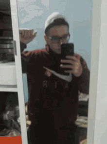 a man taking a picture of himself in a mirror wearing a nike shirt