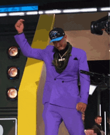 a man in a purple suit and panthers hat is dancing