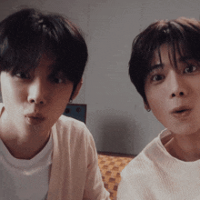 two young men are making funny faces and one is wearing a white shirt