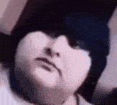 a close up of a person 's face with a black hat on their head .