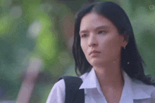 a close up of a woman 's face with a backpack on her back .
