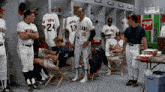 a group of baseball players in a locker room with a 7up vending machine